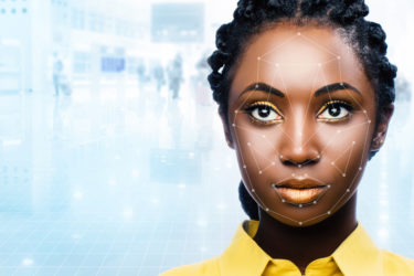 Close up portrait of attractive african woman with facial recognition technology. Grid with reference areas marked on face. Young girl against out of focus airport background.